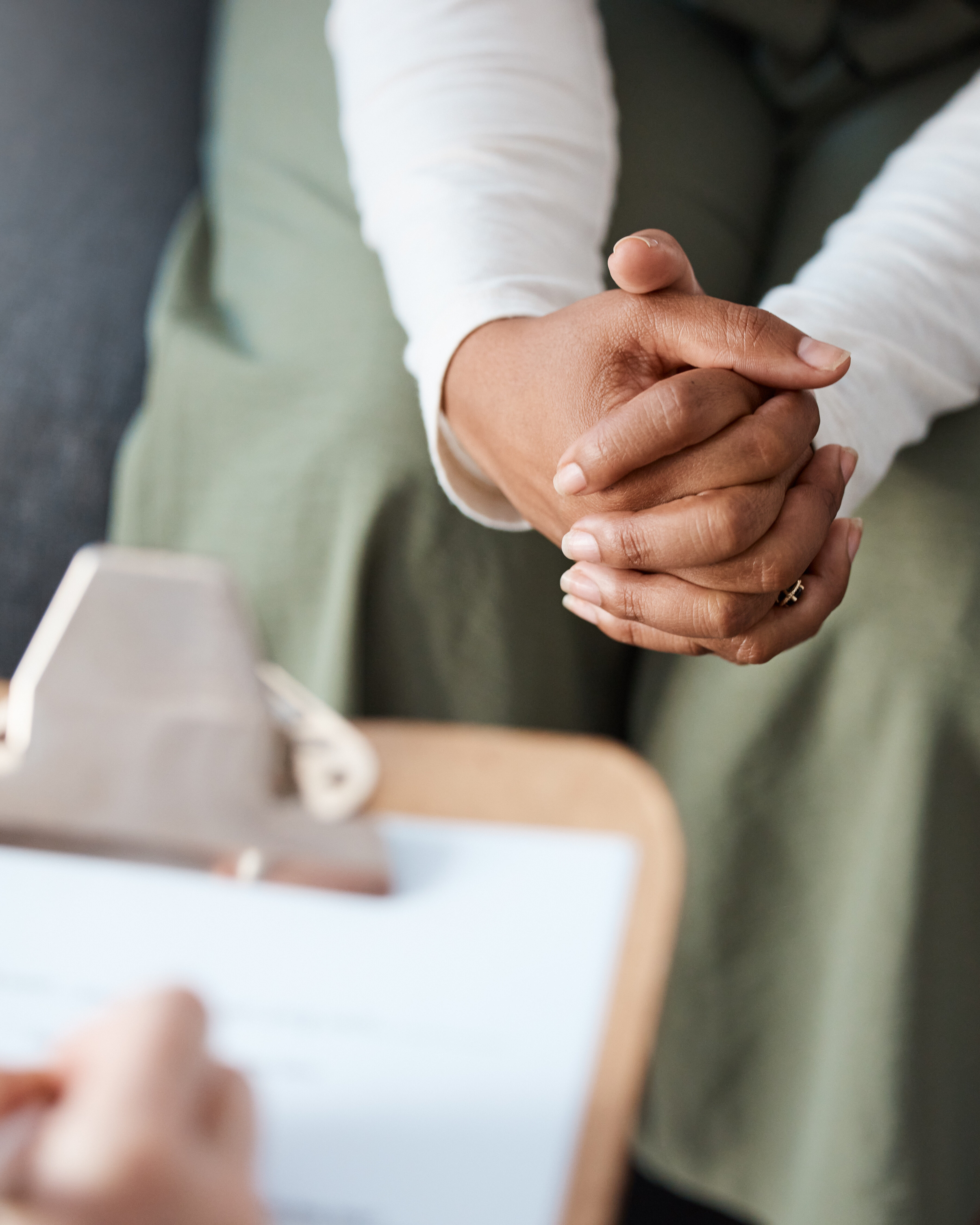 Woman, hands and therapist writing on clipboard in consultation for mental health, psychology or healthcare. Hand of female person or psychologist consulting patient with anxiety or stress in therapy